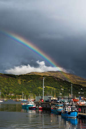 Colorful Rainbow Over Fisher Boats In The Picturesque Harbor Of Ullapool In Scotlandの写真素材
