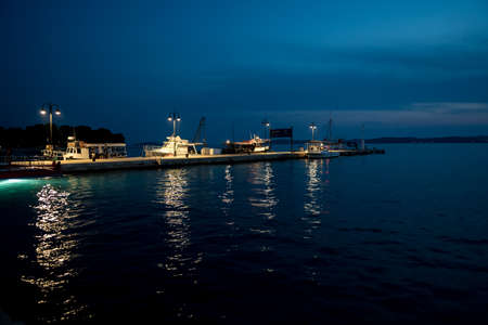 Illuminated Motorboats At Jetty In Calm Harbor In Croatiaのeditorial素材