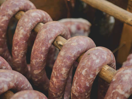 A group of smoked sausages hung on a stick over a smoke. This is a natural tasty product without preservatives or chemicals.の写真素材