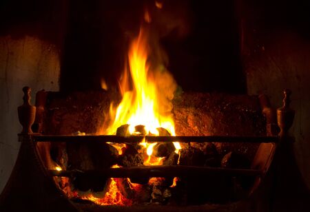Coal fire burning in grate in traditional fireplaceの写真素材