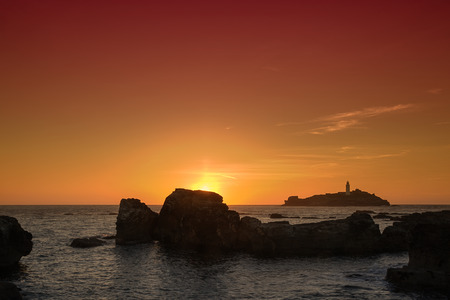 Golden sunset at Godrevy Head lighthouse, St Ives, Cornwallの写真素材