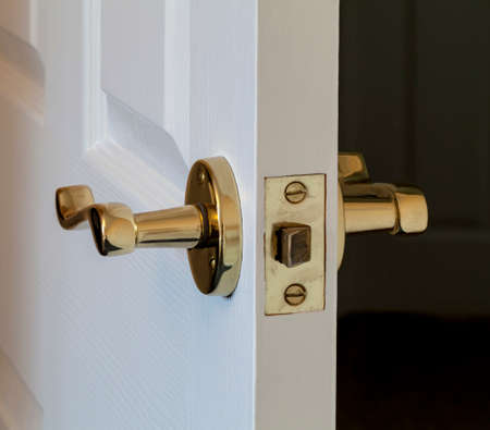 White painted internal house door partly open to show lock and handleの写真素材