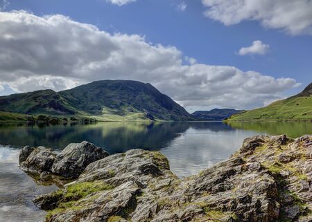 Crummock Water looking towards Mellbreak with rocks in foregroundの写真素材
