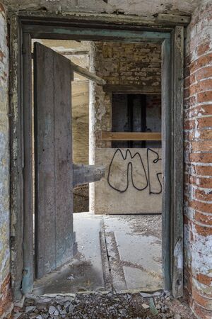 broken door in an abandoned mill buildingの写真素材