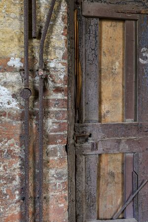 broken door and rusty pipes in an abandoned mill buildingの写真素材