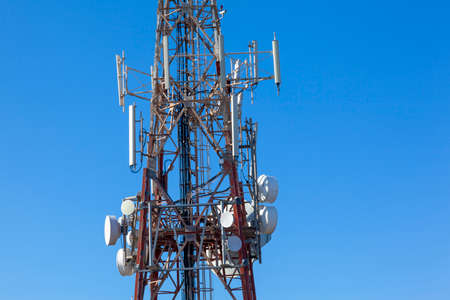 close up of telecommunications mast showing various aerials and dishes against clear blue skyの写真素材