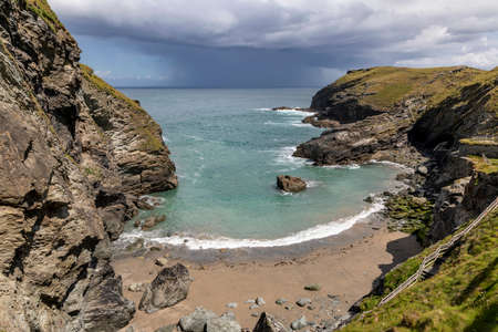 tintagel bay cornwall below the castle with clearing rain storm out to seaの写真素材