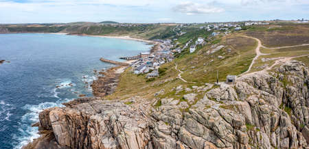 sennen cove cornwall showing rocky shore beach village cliffs and lifeboat station elevated view panoramaの写真素材