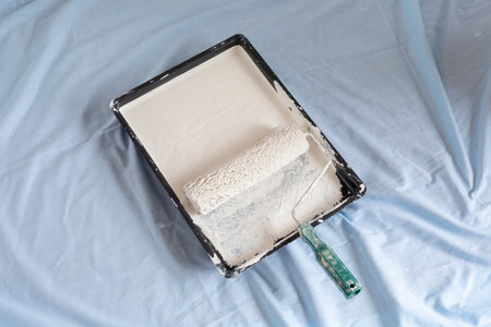 Paint tray ready to use with cream coloured paint and paint roller home decorating
