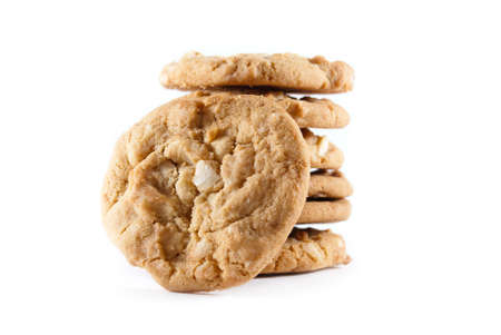 Upright cookies against a stack of macadamia nut cookies on a white isolated background.