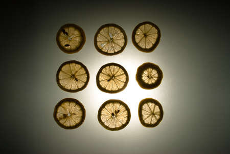 Nine lemon slices in a sqaure lit from behind.の写真素材