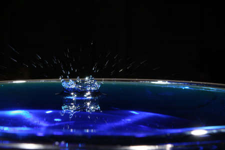 a blue water drop with a blurred splash