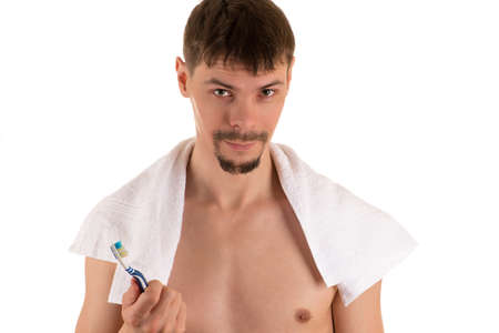 portrait of smiling adult male with white towel on his shoulders looking at camera and holding in...