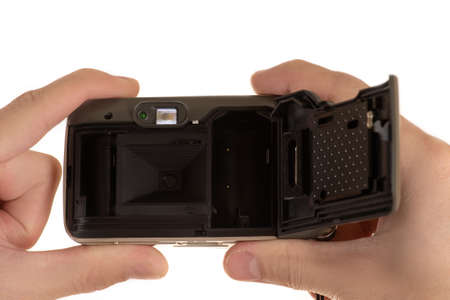 old film camera with lid shifted in hands of man closeup