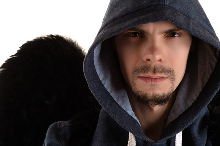portrait of young man in gray hooded and black wing of right shoulder closeupの写真素材