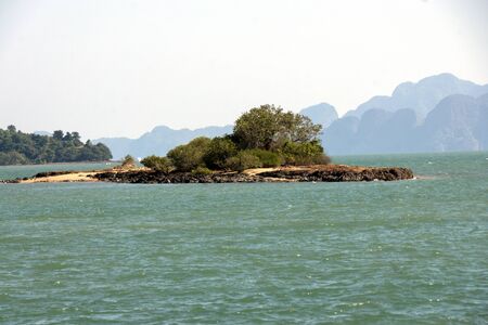 small island with a tree in the middle of the oceanの写真素材