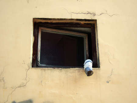 Old wooden framed window with white tube
