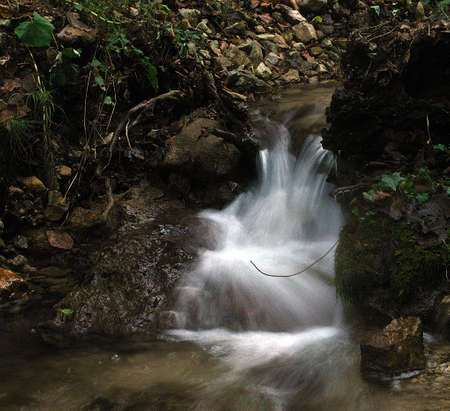 Small nice waterfall on the mountain stream