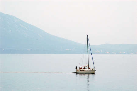 White sail boat with sailors on the sea