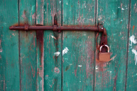 Old green wooden door on the house is closedの写真素材