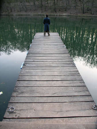 Alone girl on the old wooden moleの写真素材