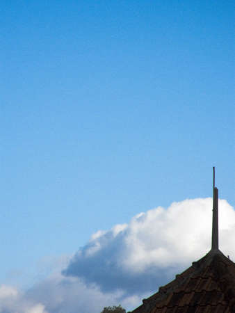 Blue sky, white clouds and tiled red roof partの写真素材