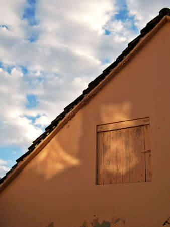 Part of house and orange colored wooden window