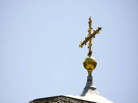 Old and shiny golden cross on the church building