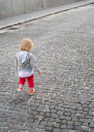 Small  girl in the walk on city streetの写真素材