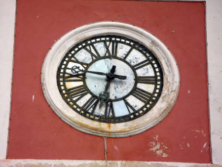 old rusted metallic clock on the building wallの写真素材