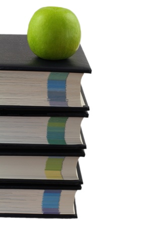 Stack of encyclopedias with green apple on top isolated on whiteの写真素材