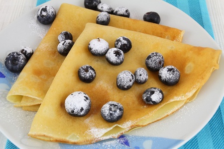 Crepes with blueberries dusted with icing sugarの写真素材