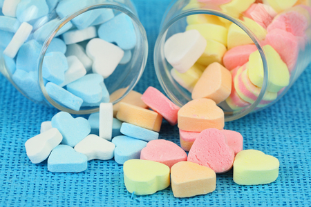 Colorful sugar hearts in transparent bottles, close upの写真素材