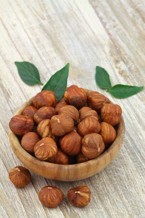 Whole hazelnuts without shell in wooden bowl with copy spaceの写真素材