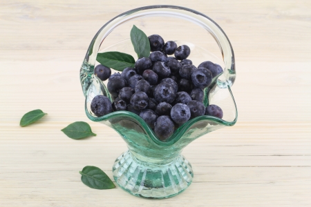 Blueberries in vintage glass basketの写真素材