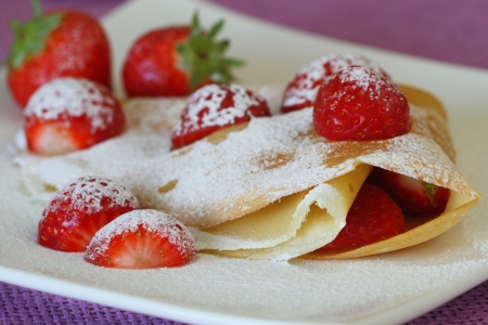 Crepe with strawberries dusted with icing sugarの写真素材