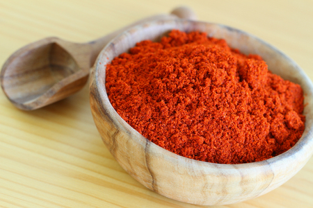 Chili powder in wooden bowl, close upの写真素材