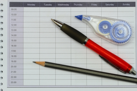 Pencil, pen and pen corrector on open agendaの写真素材