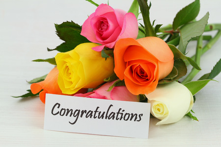 Congratulations card with colorful roses bouquet on white wooden surfaceの写真素材