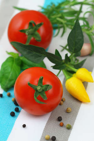 Cherry tomatoes with selection of fresh herbs and mixed peppersの写真素材
