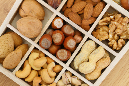 Selection of nuts and almonds in wooden compartmentsの写真素材