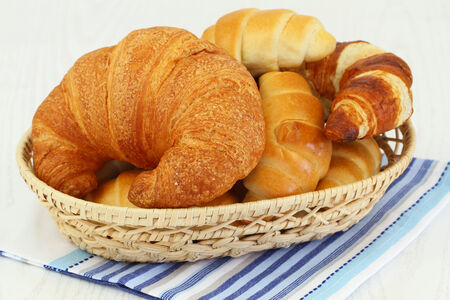 Butter croissants in bread basket, close upの写真素材