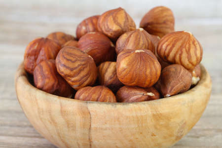 Hazelnuts in wooden bowl, close upの写真素材