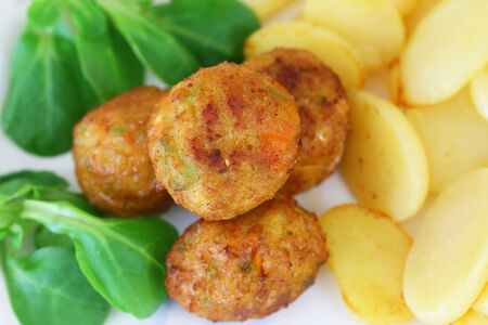 Vegetarian balls, fried potatoes and corn salad, closeup