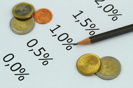 Interest rates listed on piece of paper and Euro coins