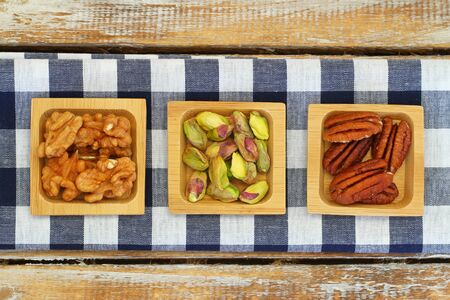 Pistachio pecan nuts and walnuts on checkered clothの写真素材