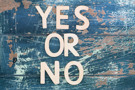 Yes or no written with wooden letters on rustic wooden surfaceの写真素材