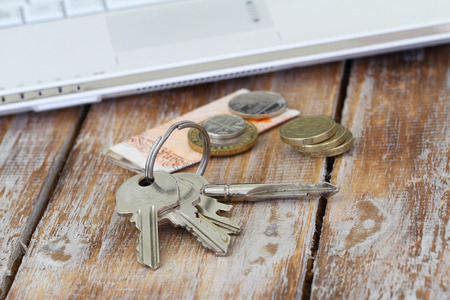Bunch of keys on rustic surface and some change in British poundsの写真素材