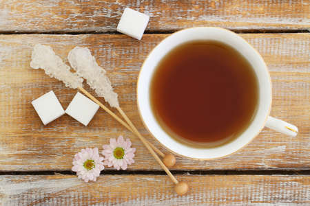 Cup of black tea and sugar sticks on rustic wooden surfaceの写真素材