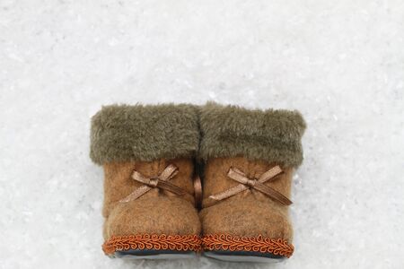 Felt booties on snowy surface with copyspace